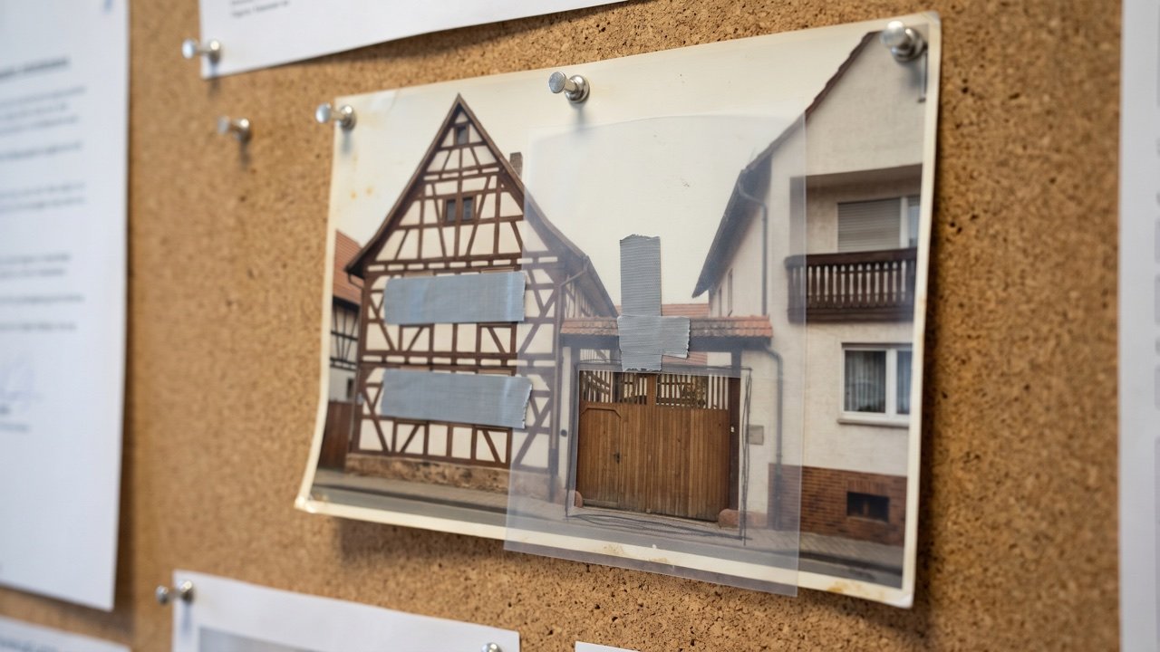Angeheftetes Fassadenfoto mit Folie, Bleistift-Rechteck um das Tor, graues Klebeband über Fenstern und Nachbarbalkon